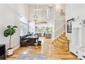 Bright, open-concept living room with dining area, beautiful staircase, and hardwood floors at 1441 Cherry Pl, Erie, CO 80516