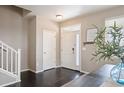 Inviting foyer featuring hardwood floors, a staircase, and a stylish front door at 25403 E 2Nd Ave, Aurora, CO 80018