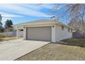 Ranch-style home with a two-car garage, long driveway and manicured lawn in a suburban neighborhood at 3293 S Florence Ct, Denver, CO 80231