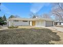 Ranch-style home with brick exterior, attached garage and a lawn in a suburban neighborhood at 3293 S Florence Ct, Denver, CO 80231