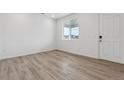 Bright bedroom with light wood flooring, a large window, and white door at 19120 E 96Th Pl, Commerce City, CO 80022