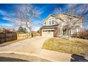 Lovely two-story home with an attached garage and manicured lawn on a sunny day at 23201 E Orchard Pl, Aurora, CO 80015