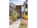 Inviting front entrance with a unique arched window above the door and stone pathway lined with landscaping at 1448 E Maplewood Ct, Centennial, CO 80121