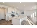 Open concept kitchen with white cabinets, quartz countertops, and an island at 196 Kino Ct, Brighton, CO 80601