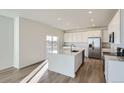 Modern kitchen featuring island, stainless steel appliances, and light wood floors at 196 Kino Ct, Brighton, CO 80601