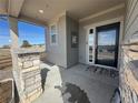 Inviting front porch with stone pillars and a black front door, enhancing curb appeal and welcome at 914 Peach Leaf Ln, Elizabeth, CO 80107