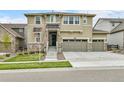 A two-story house with stone accents, a three-car garage, and a well-maintained lawn on a sunny day at 22472 E Narrowleaf Cir, Aurora, CO 80016