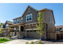Beautiful two-story home featuring a stone facade, covered porch, and a well-manicured front yard at 24326 E Ohio Dr, Aurora, CO 80018
