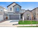 Two-story home featuring a two-car garage, gray siding and a well-maintained lawn at 9982 Wheeling St, Commerce City, CO 80022