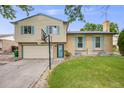 Charming home with a two-car garage, a basketball hoop, and blue shutters in front of a green lawn at 1549 S Evanston St, Aurora, CO 80012