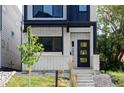 Striking front entrance of a modern home, featuring a black door, light brick, and neat landscaping at 3435 W 17Th Ave, Denver, CO 80204