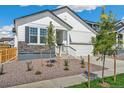 White, two-story home boasting a well-maintained front yard and a two-car garage at 13575 E 110Th Ln, Commerce City, CO 80022