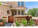 A charming entryway boasts a private gated area with desert landscaping and unique decorative elements at 9117 Nambe Trl, Lone Tree, CO 80124