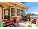 Inviting front porch with decorative mat, chairs, plants, and tiled accents offers a cozy welcome at 9117 Nambe Trl, Lone Tree, CO 80124