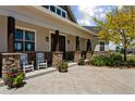 Cozy front porch with dark wood pillars, stone accents, and rocking chairs at 3048 Deer Creek Ranch Loop, Parker, CO 80138
