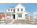 Two-story white farmhouse with a charming front porch and landscaping at 8373 Rush Creek Ave, Littleton, CO 80125