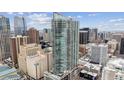 Modern high-rise building with floor-to-ceiling windows set against a vibrant city skyline under a bright, cloudy sky at 891 14Th St # 2703, Denver, CO 80202