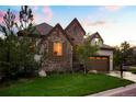 Beautiful stone and stucco home with a well-kept lawn and mature trees enhancing its appeal at 6840 Northstar Cir, Castle Rock, CO 80108