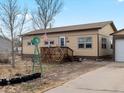 House with a deck, windmill, and well-maintained yard at 635 2Nd St, Bennett, CO 80102