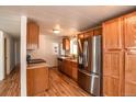 This bright kitchen features wood cabinets, stainless-steel appliances, and hardwood floors at 635 2Nd St, Bennett, CO 80102