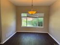 Cozy dining room with warm paint, dark wood floors, and a window overlooking the greenery outside at 1251 N Burlington Dr, Castle Rock, CO 80104
