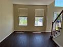 Inviting living room featuring dark wood floors, neutral walls, and natural light from the large windows at 1251 N Burlington Dr, Castle Rock, CO 80104
