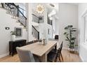 Bright dining room featuring a modern chandelier, open staircase and hardwood floors at 4505 S Yosemite St # 362, Denver, CO 80237