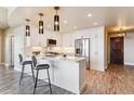 Modern white kitchen with stainless steel appliances and breakfast bar at 2990 E 17Th Ave # 604, Denver, CO 80206