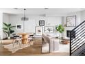 Open-concept living area features a dining table and cozy seating adjacent to a fireplace, all styled with neutral accents at 2820 W 26Th Ave # 101, Denver, CO 80211