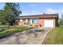 Charming single-story home featuring a driveway, manicured lawn, and beautiful landscaping at 3061 S Mabry Ct, Denver, CO 80236