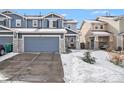 Inviting two-story home with a two-car garage, stone accents, and snow-covered landscaping at 6210 Wescroft Ave, Castle Rock, CO 80104