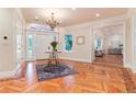 Bright foyer featuring decorative wood floor pattern, chandelier, and open access to adjacent living spaces at 4800 S Franklin St, Cherry Hills Village, CO 80113