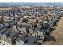 Aerial shot of a community with modern townhomes and surrounding landscape, including city and mountains at 8855 E 55Th Ave, Denver, CO 80238