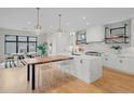 Open-concept kitchen with island, counter seating, modern cabinets, and herringbone backsplash at 1085 S Cook St, Denver, CO 80209