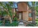 Two-story townhouse with brick and wood, showcasing a landscaped entryway and cozy facade at 2685 S Dayton Way # 253, Denver, CO 80231