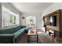 Sunlit living room with a large window, plush sectional sofa, and a view into the adjacent dining area at 60 Vrain St, Denver, CO 80219