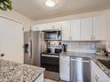 Updated kitchen with granite counters, white cabinets, and stainless steel appliances at 6332 Zang Court # A, Arvada, CO 80004