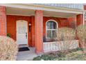 Inviting front porch with red brick columns and a cozy seating area with arched windows at 404 S Grant St, Denver, CO 80209