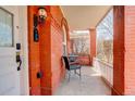 Relaxing front porch featuring red brick columns, a charming sitting area, and a stylish wall lamp at 404 S Grant St, Denver, CO 80209