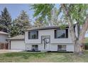 Beautiful exterior view of a white home with black trim and a well-kept lawn at 5945 W 86Th Ave, Arvada, CO 80003