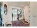 Bright foyer with hardwood floors, elegant staircase, and an open view to the living area at 14551 Hudson St, Thornton, CO 80602