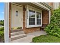 Inviting front porch with brick accents, a cozy bench, and a well-lit entrance at 14396 E Temple Pl # D, Aurora, CO 80015