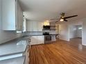 Open kitchen featuring stainless steel appliances, white cabinets, and hardwood floors at 4670 Independence St, Wheat Ridge, CO 80033