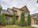 Well maintained two story home with manicured bushes and a stone garage facade at 5553 Jasper St, Denver, CO 80239