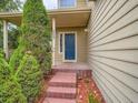 Charming home entrance with brick steps, blue door, and decorative plants at 5553 Jasper St, Denver, CO 80239