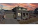 Lovely two-story home boasts stone accents, a covered porch, and a two-car garage with sunset sky at 3925 W 149Th Ave, Broomfield, CO 80023