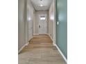 Inviting entryway with light wood-look floors and a white front door with glass panels at 11464 Stonewash St, Littleton, CO 80125