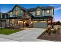 Lovely two-story home with stone detailing, warm exterior lights, and an attached two-car garage at 7173 S Shady Grove Ct, Aurora, CO 80016