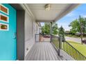 Inviting front porch with gray brick exterior, stylish railing, and a pop of color from the bright blue door at 1655 Yates St, Denver, CO 80204