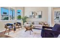 Bright living room with modern furniture, neutral tones, and natural light streaming through large windows at 4257 S Andes Way, Aurora, CO 80013